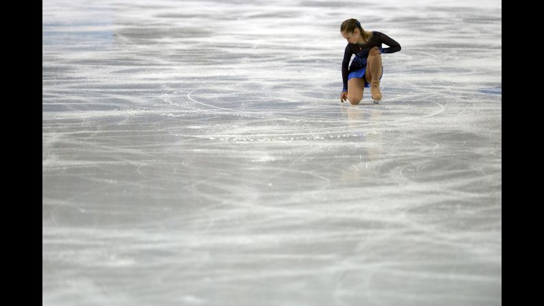 Russia's Julia Lipnitskaia runs her fingers across the ice February 8 as she competes in the women's short program during the team figure skating event.