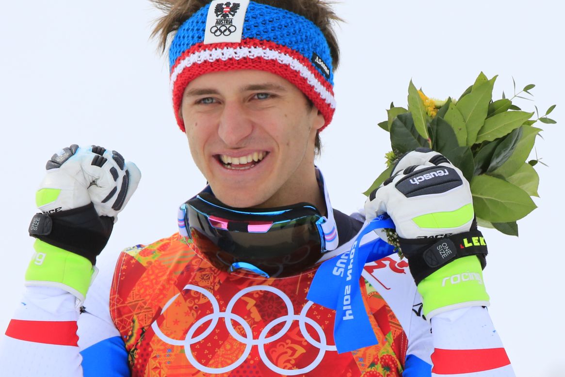 Golden boy: Matthias Mayer of Austria celebrates on the podium after winning the men's downhill in Sochi.