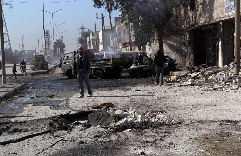 A man stands next to debris in the road following a reported airstrike by Syrian government forces in Aleppo on February 8.