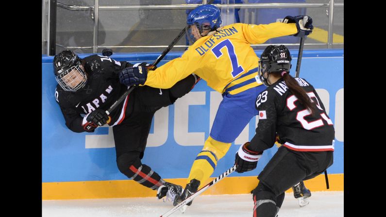 Sweden's Johanna Olofsson, center, vies with Japan's Haruna Yoneyama, left, during their Group B hockey game February 9.