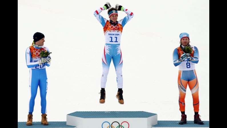 Austria's Matthias Mayer jumps on the medal podium after the downhill event.