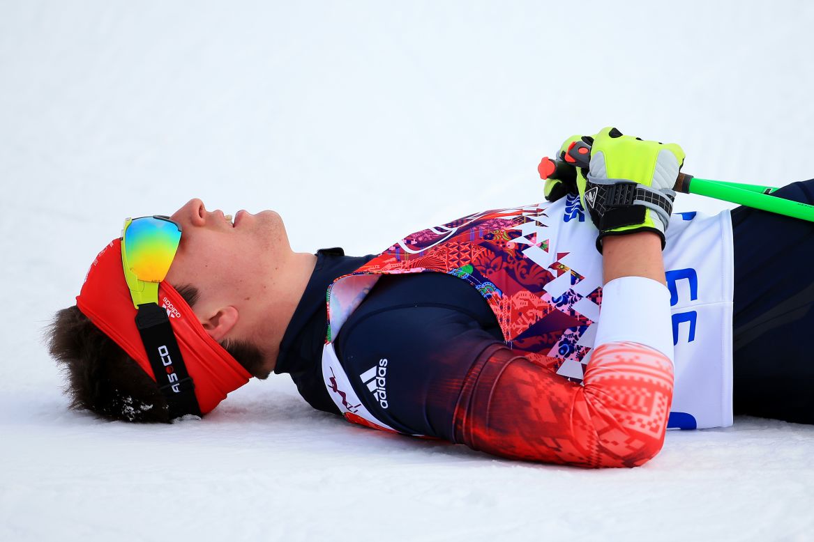 Callum Smith of Great Britain rests at the finish line of the men's skiathlon.