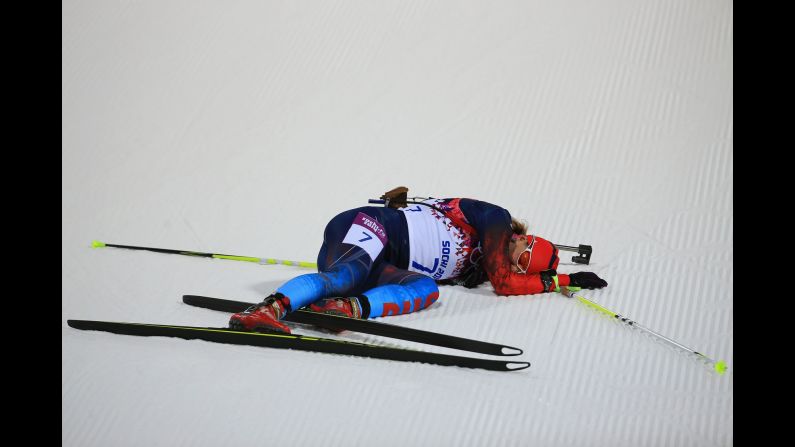 Biathlete Ekaterina Shumilova of Russia collapses on the snow February 9 after crossing the finish line in the women's 7.5-kilometer sprint.