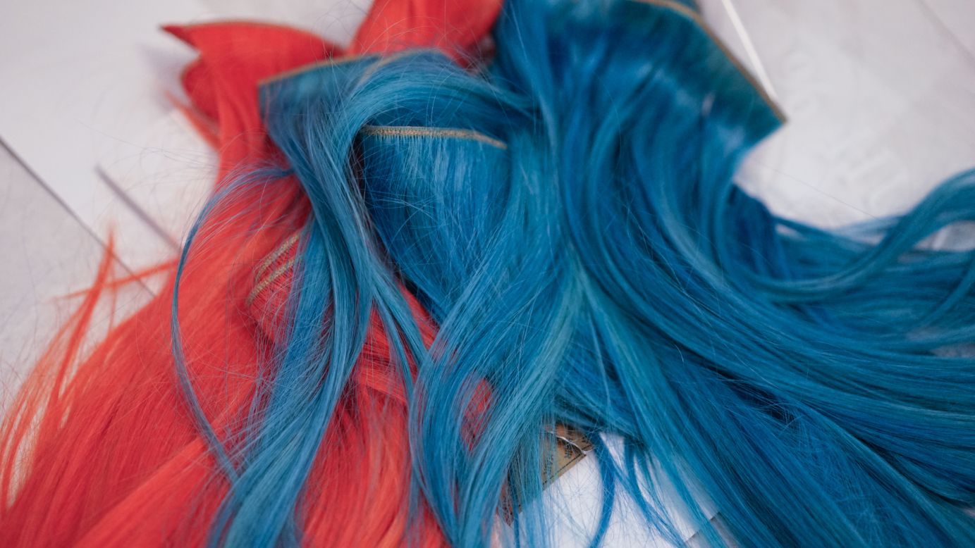 Blue and coral extensions are prepped for models' ponytails before the Herve Leger show.
