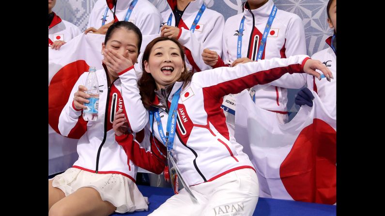 Japan's Akiko Suzuki and coach Miho Kawaume wait for Suzuki's score February 9 after the women's free skate portion of the team figure skating event.
