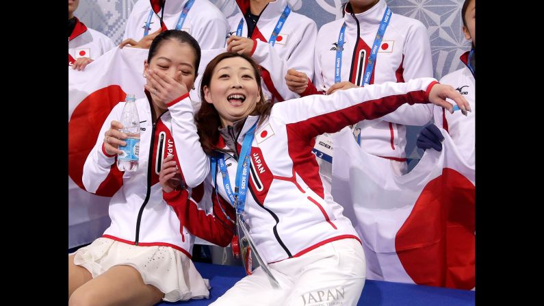 Japan's Akiko Suzuki and coach Miho Kawaume wait for Suzuki's score February 9 after the women's free skate portion of the team figure skating event. 