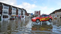 A car dealership's display model sits on a ramp above floodwaters in Datchet, England, on February Monday, 10.