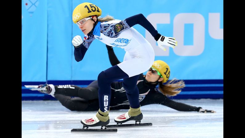 Short track speedskater Jessica Smith of the United States falls as Valeriya Reznik of Russia skates past her during the 500-meter preliminaries on February 10.