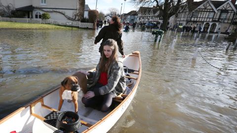 People evacuate homes after the River Thames burst its banks on Monday in Datchet, England. 