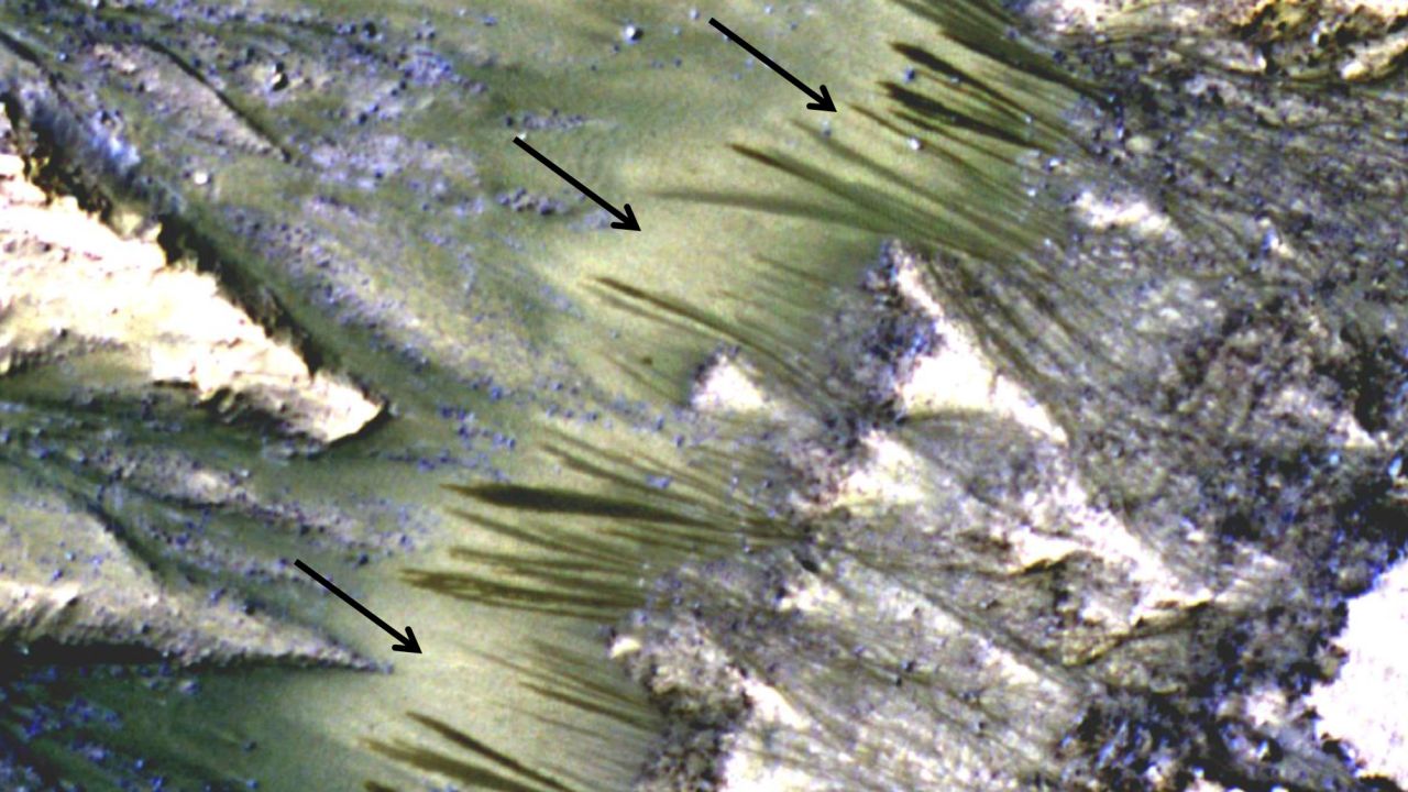 Arrows point to dark seasonal flows on Palikir Crater on Mars in this image from NASA's Mars Reconnaissance Orbiter.