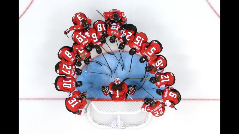 The Canadian women's ice hockey team talks at the net prior to a preliminary round game on February 10.