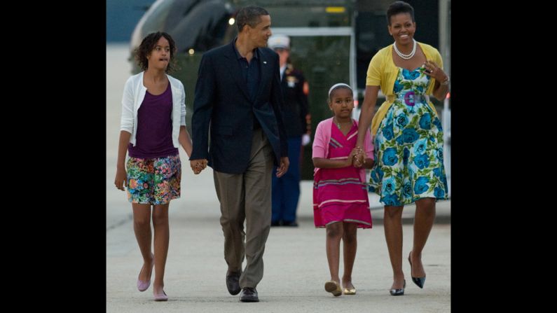In 2009, President Barack Obama walks with daughters Sasha and Malia and first lady Michelle Obama -- all wearing cardigans. Michelle Obama wears a sweater from Dear Cashmere, a belt by Sonia Rykiel and a dress from Talbots.