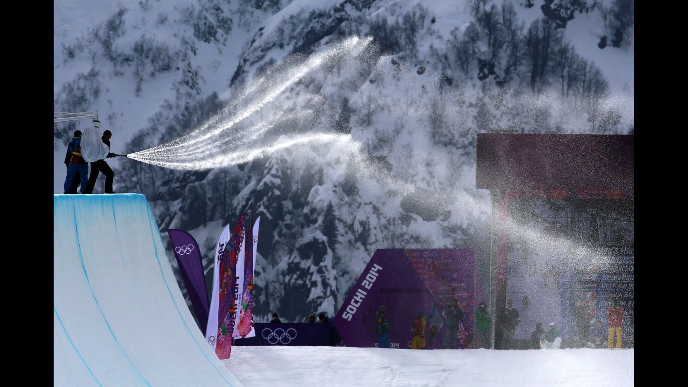 Workers spray down the halfpipe before competition begins in men's snowboarding February 11.