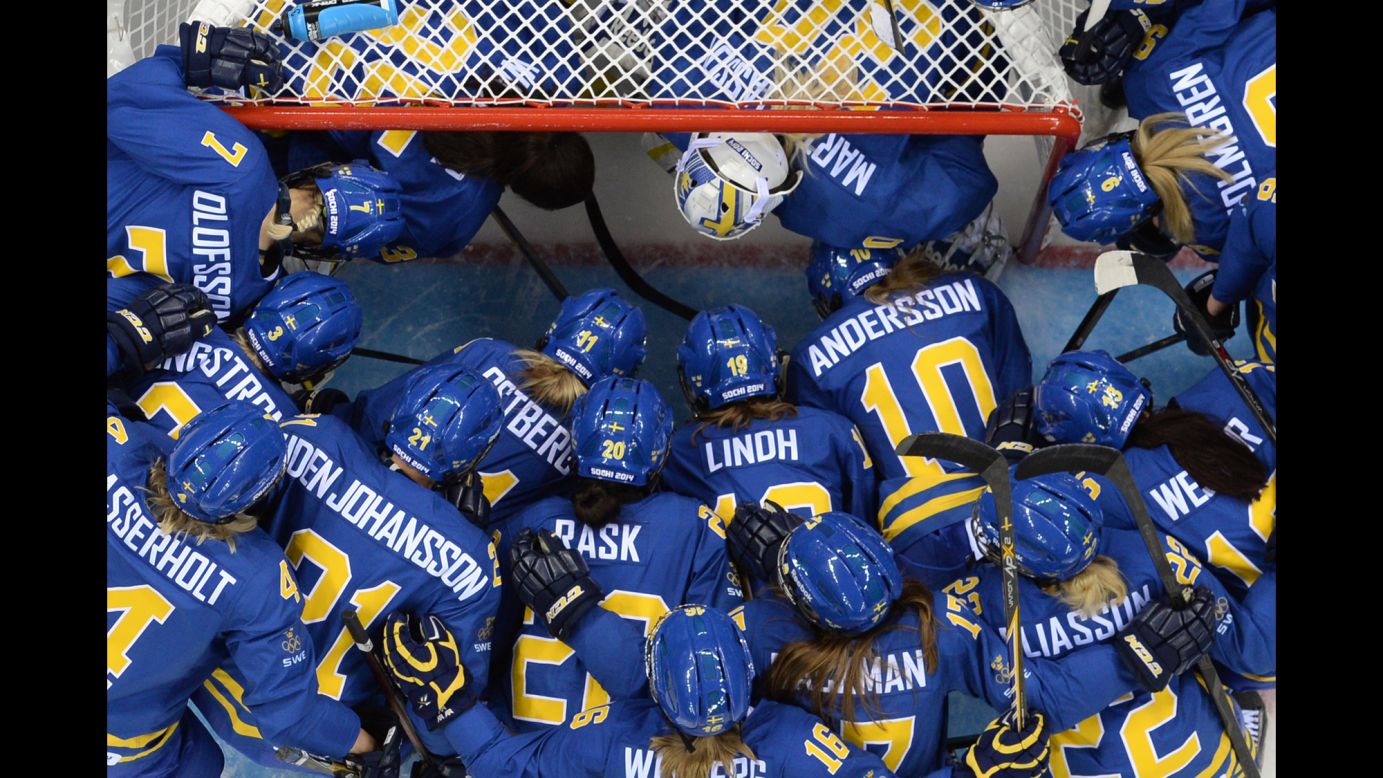 Sweden's players gather at the net before the women's Group B hockey match between Sweden and Germany on February 11.