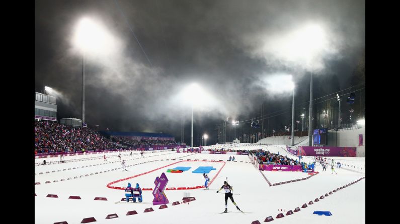 Slovakian biathlete Anastasiya Kuzmina, foreground, skis away from the shooting range during the 10-kilometer pursuit on February 11.