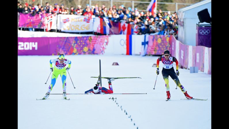 Norway's Marit Bjoergen falls as she competes with Katja Visnar of Slovenia, left, and Denise Herrmann of Germany during the finals of the women's cross-country sprint on February 11.