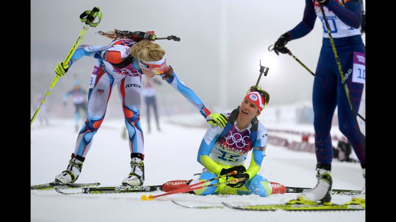 Slovenian biathlete Teja Gregorin, center, collapses at the finish line of the women's 10-kilometer pursuit on February 11.