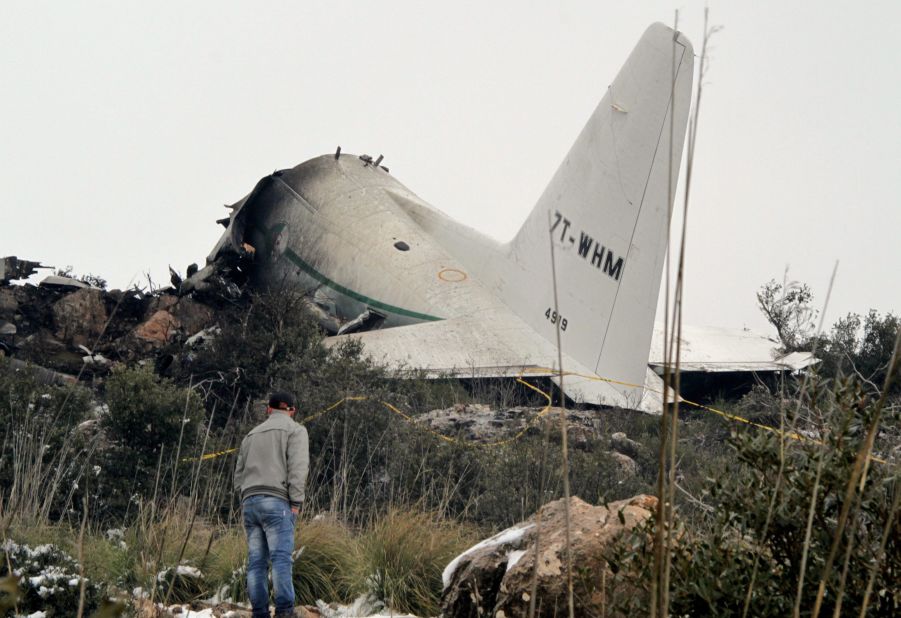 A man surveys the damage after a military plane crashed in the mountains of eastern Algeria on Tuesday, February 11. Rescue workers recovered at least 77 bodies and found one survivor, officials said.