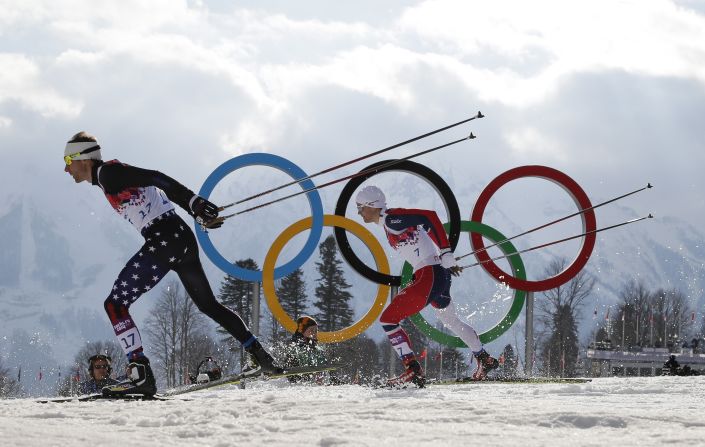 Andrew Newell of the United States leads Norway's Eirik Brandsdal as they ski past the Olympic rings during the men's cross-country sprint on Tuesday, February 11.