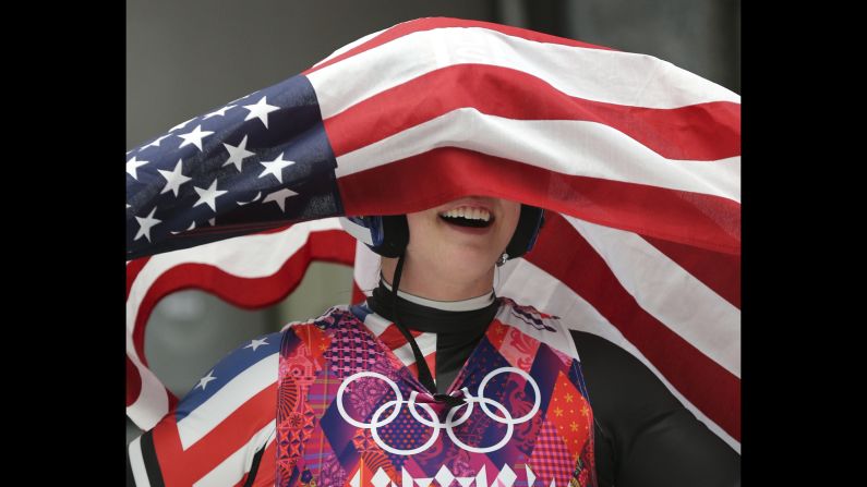 Erin Hamlin is covered by the American flag after she finished third in the women's luge on February 11.