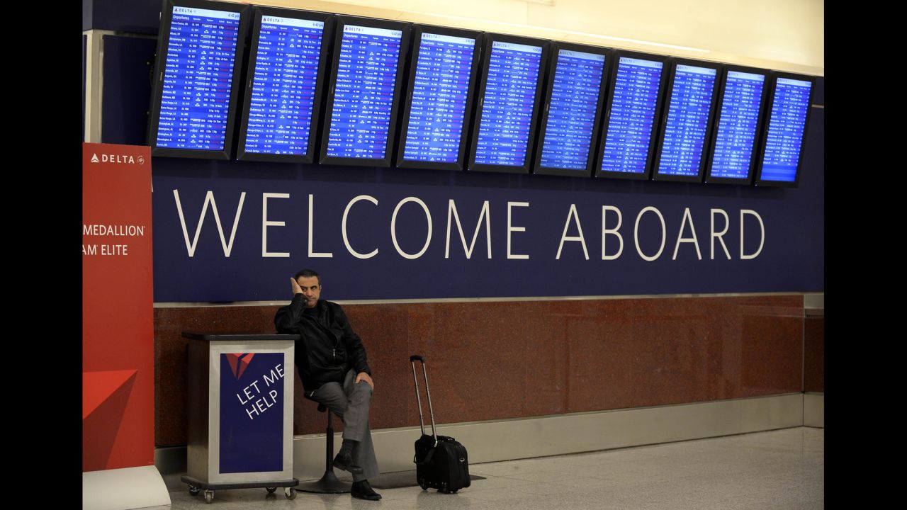 Hossam Shalaby waits for his rescheduled flight under a departure board at Hartsfield-Jackson Atlanta International Airport on Tuesday, February 11.