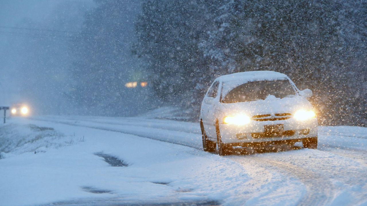 Vehicles slowly make their way over a snow-covered Route 35 in Fort Payne, Alabama, on February 11.