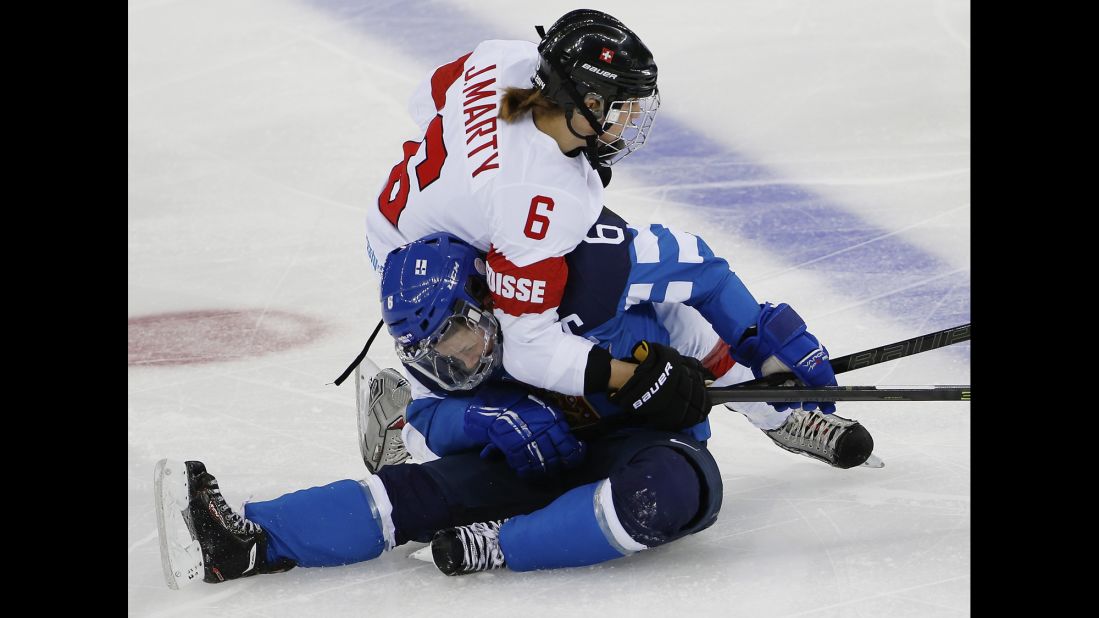 Julia Marty of Switzerland and Jenni Hiirikoski of Finland collide during the second period of their women's hockey game February 12.