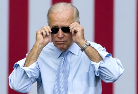 Joe Biden removes his sunglasses as he arrives for a campaign event with President Obama in Portsmouth, New Hampshire, in September 2012.