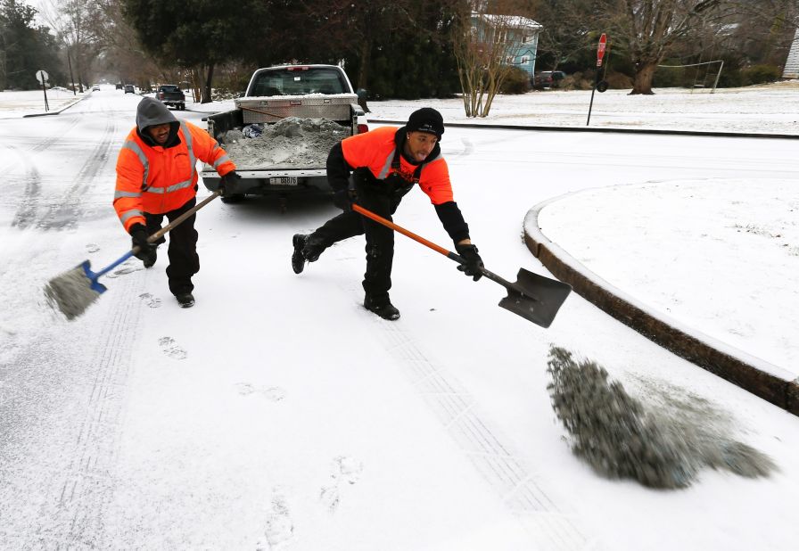 City workers spread a mixture of sand and salt on an intersection in Avondale Estates, Georgia, on February 12.
