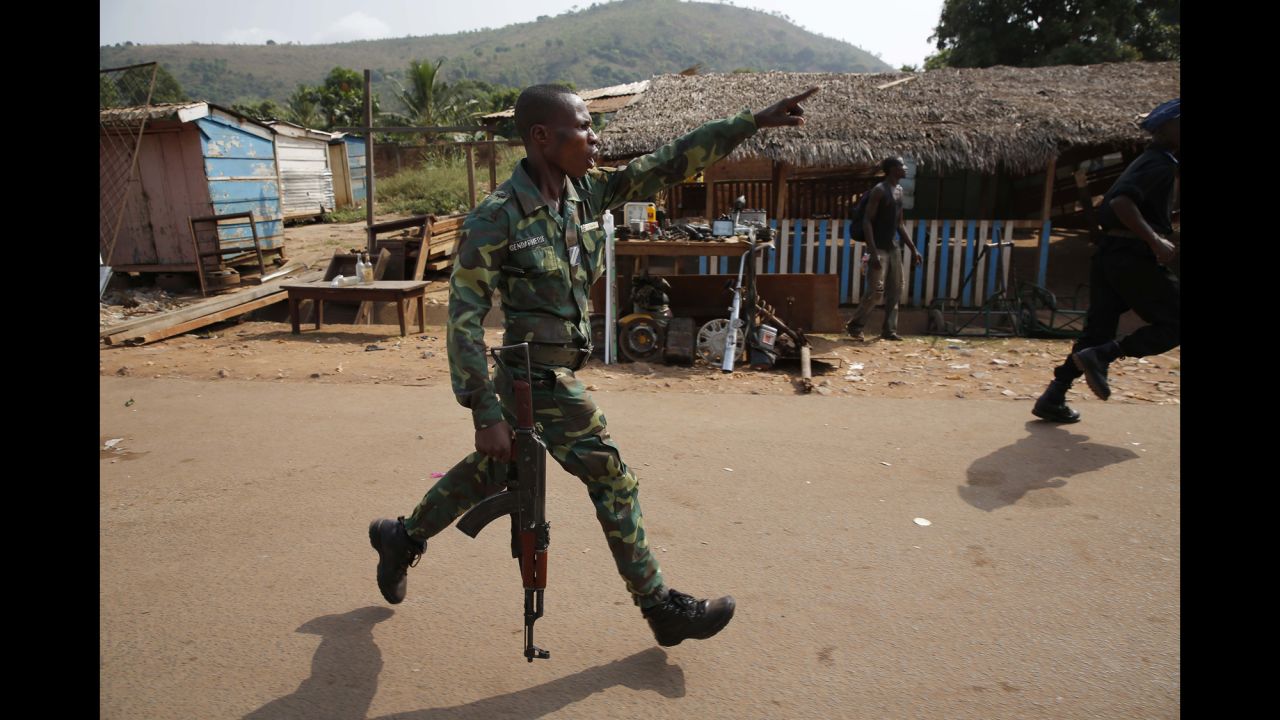 A Central African Republic police officer chases looters attacking a broken-down truck Friday, February 7, in the capital of Bangui. The country, a former French colony, was plunged into chaos last year after a coalition of mostly Muslim rebels ousted President Francois Bozize.