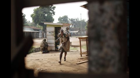 A woman runs for cover as heavy gunfire erupts in the Miskin district of Bangui on Monday, February 3.