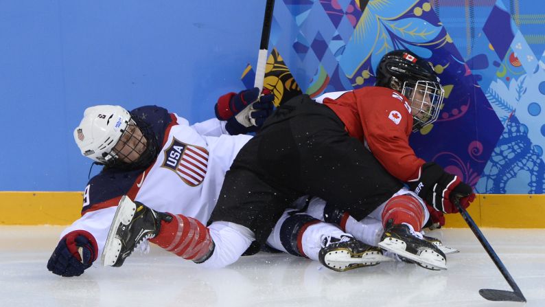 Megan Bozek of the United States, left, vies for the puck with Marie-Philip Poulin of Canada during their hockey game February 12.