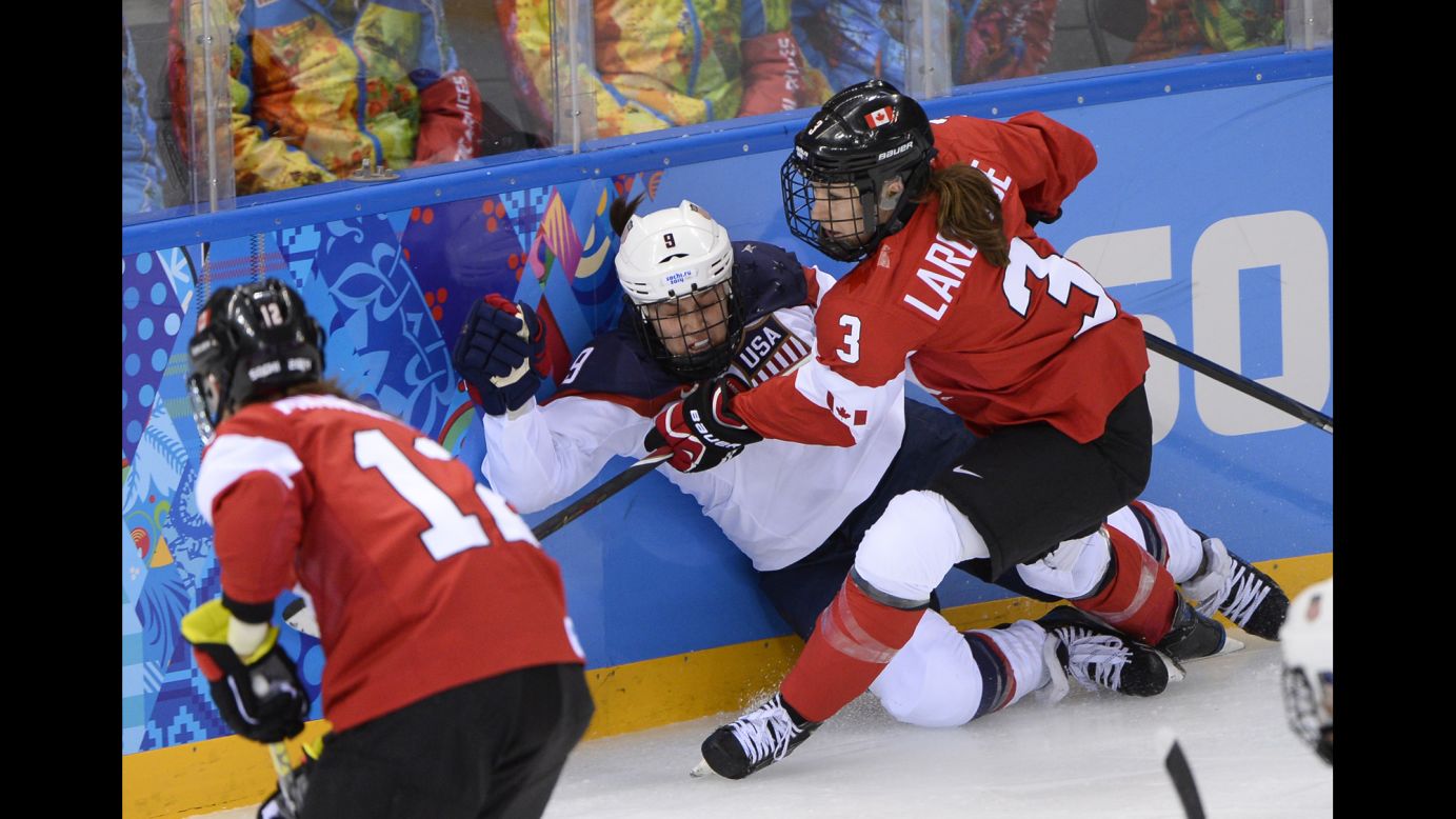 Canada's Jocelyne Larocque, right, checks Megan Bozek of the United States during their hockey game.