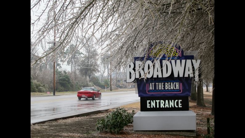 Ice coats trees hanging over a sign for the Broadway at the Beach tourist attraction in Myrtle Beach, South Carolina, on February 12.