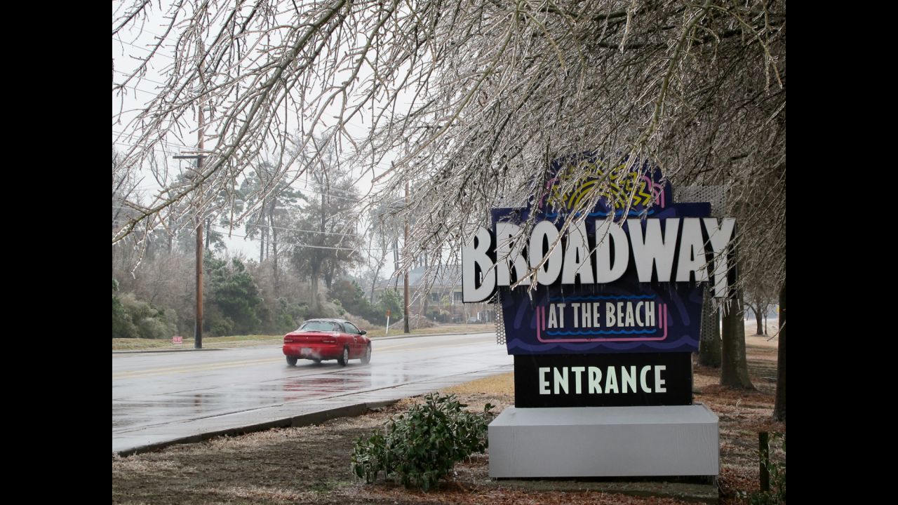 Ice coats trees hanging over a sign for the Broadway at the Beach tourist attraction in Myrtle Beach, South Carolina, on February 12.