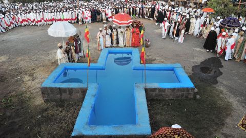 Ethiopian Orthodox Christian priests bless a cross shaped pool of water during the annual festival of Timkat in Lalibela, Ethiopia which celebrates Epiphany, the Baptism of Jesus in the Jordan River, on January 20, 2012. During Timkat, the Tabot, a model of the Ark of the Covenant is taken out of every Ethiopian church for 24 hours and paraded during a procession in towns across the country. Over 80 % of Ethiopians are estimated to be Orthodox Christians. Ethiopian Orthodox Christians believe the real Ark of the Covenant ( a vessel containing the Ten Commandments) is held in Aksum. It is guarded by a select group of monks, whose sole commitment is to protect the sacred vessel.