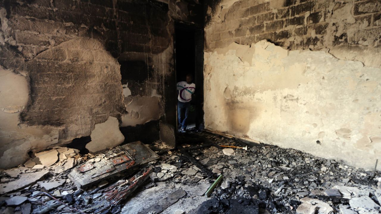 A man inspects a destroyed room at Libya's Al-Asema TV station in Tripoli after it was attacked February 12, 2014.