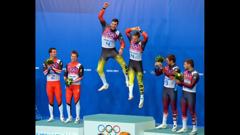 Germany's Tobias Arlt and Tobias Wendl jump on the podium after winning gold in luge doubles on February 12.