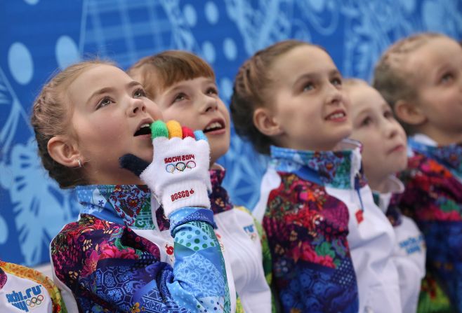 Flower girls watch the pairs figure skating competition on February 12.