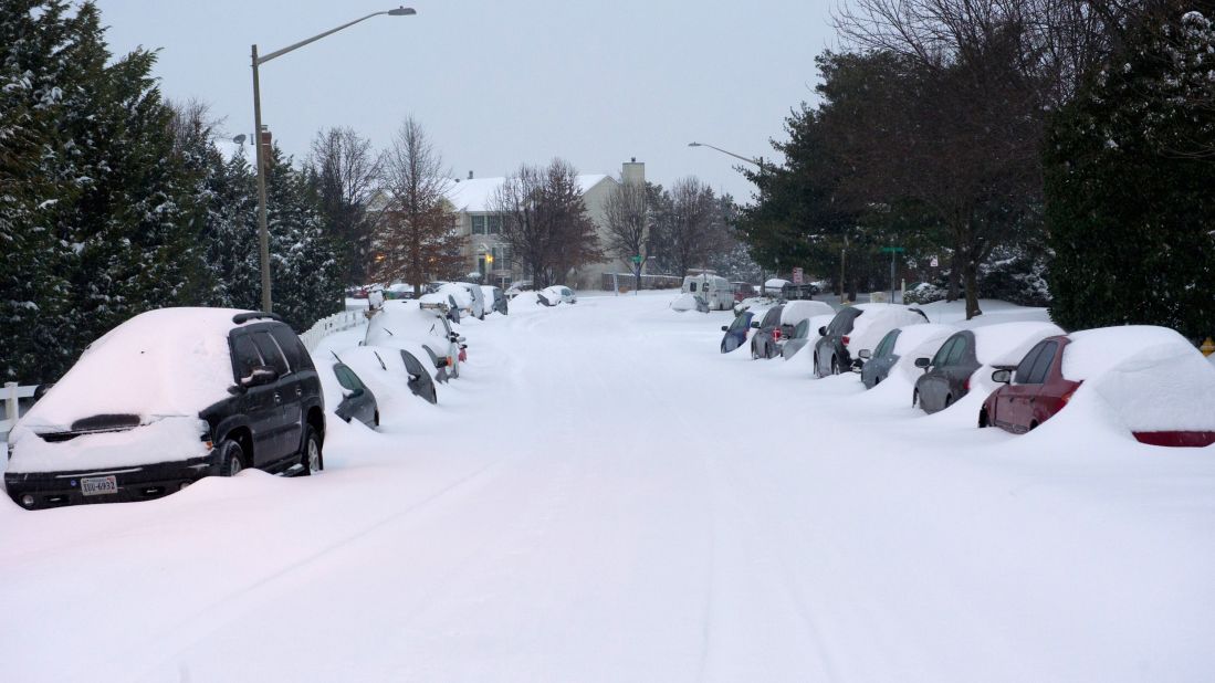 Cars sit covered in snow on a street in Manassas, Virginia, on February 13.