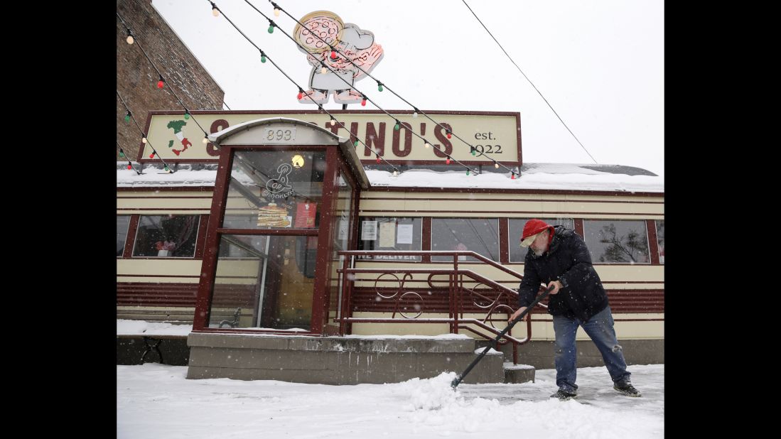 Lyall MacFee shovels snow in front of Sciortino's Pizzeria in Albany, New York, on February 13.