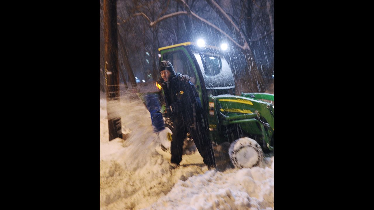 A man digs out a small snowplow that got stuck while clearing snow from a sidewalk in Chevy Chase, Maryland, on February 13.