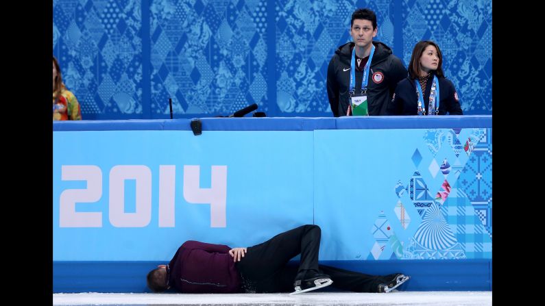 Jeremy Abbott of the United States hits the wall in front of his coaches, Yuka Sato and Jason Dungjen, while competing in the men's individual event on February 13.