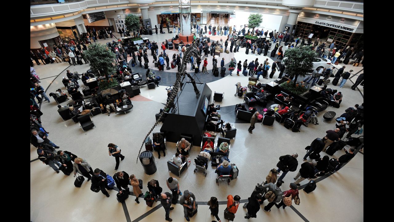 A long line of travelers winds around the atrium of Hartsfield-Jackson Atlanta International Airport on February 13 as people attempt to catch flights previously canceled because of the massive winter storm. 