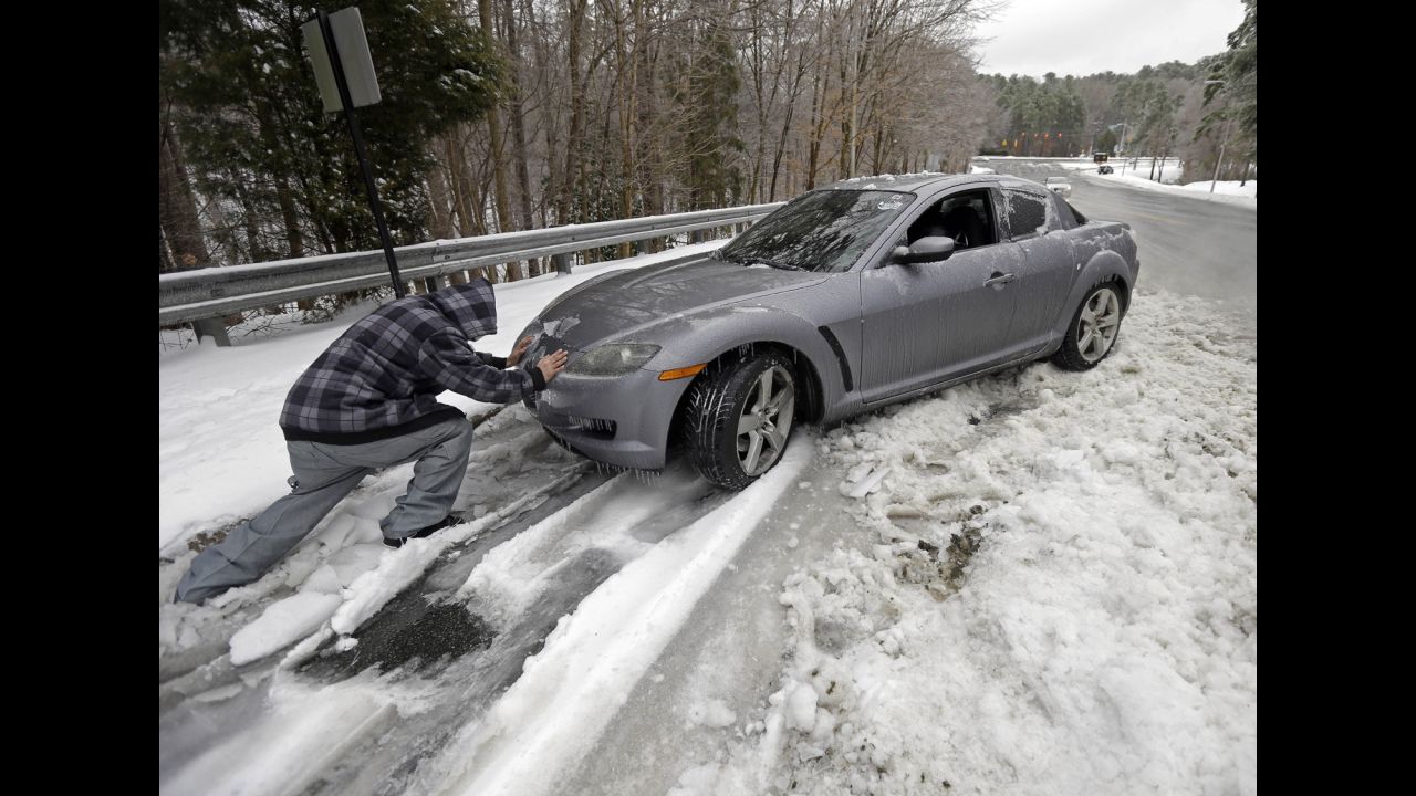 A man helps push a car in Chapel Hill, North Carolina, on February 13.