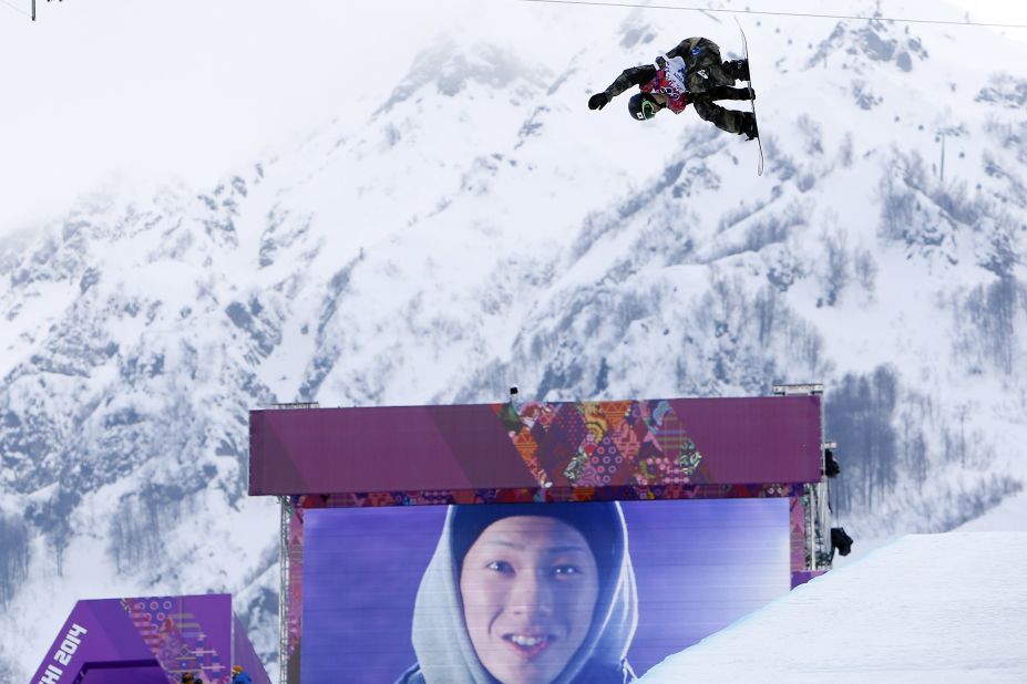 The cool image of snowboarding is reinforced by big screens showing the competitors posing for cameras.  Here, Taku Hiraoka of Japan competes during the halfpipe event.