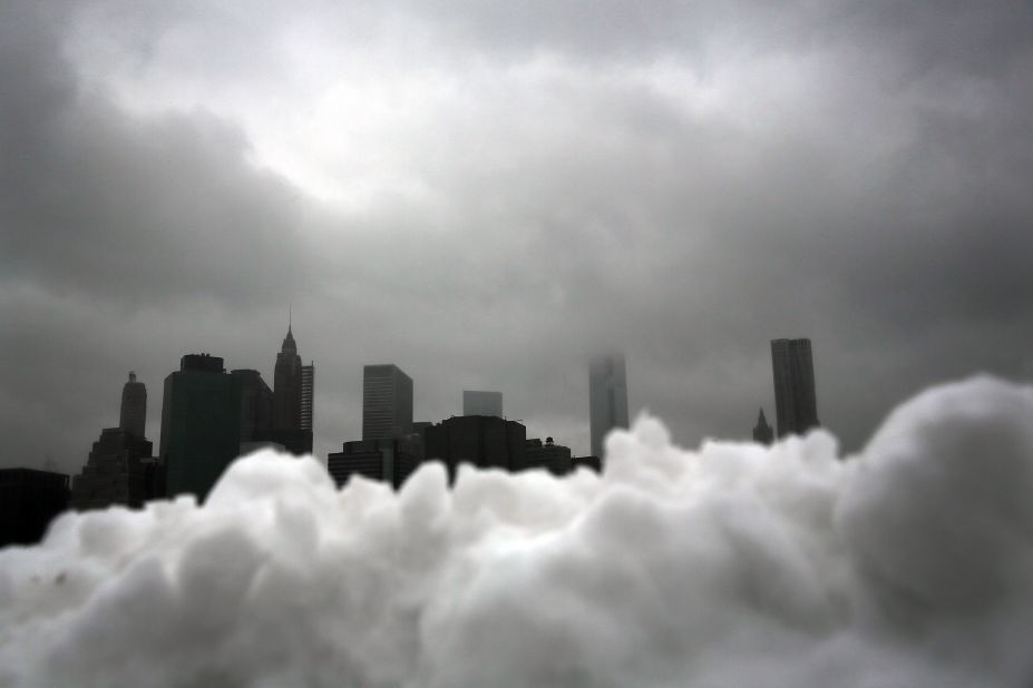 The lower Manhattan skyline is seen behind a pile of snow in Brooklyn on February 13.