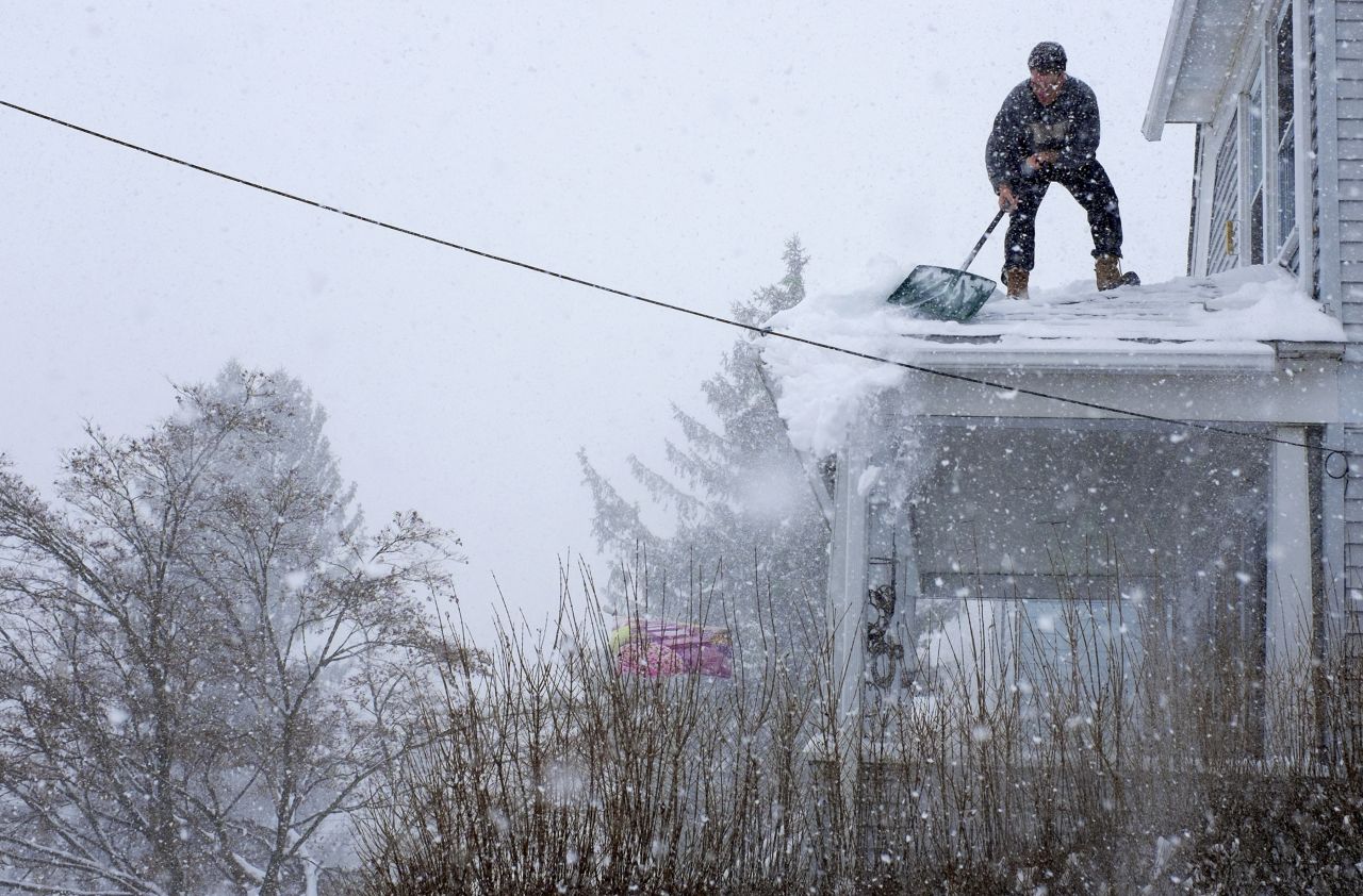 Chris Starace works to clear snow from his roof in Ossining, New York, on Thursday, February 13.
