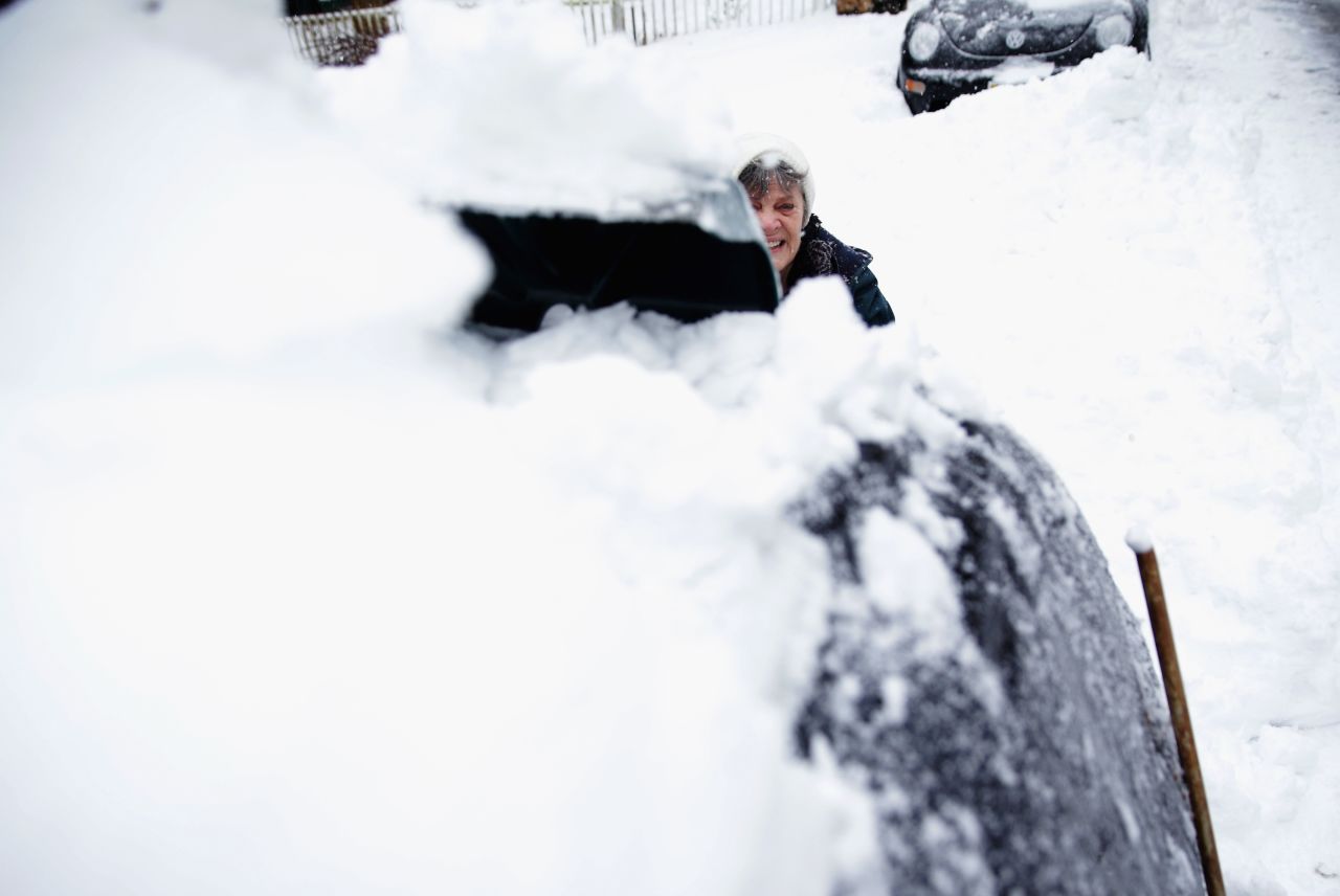 Claire Lamborne removes snow from her car in Warrenton, Virginia, on February 13.