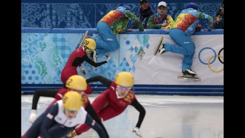 Track wardens attempt to clear the way as Fan Kexin of China crashes in the semifinals of the women's 500-meter short track speedskating competition on February 13. 